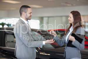 Woman giving car keys to a client