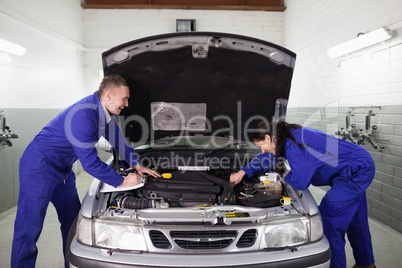 Mechanics examining a car engine