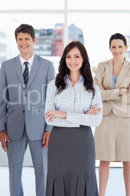 Young businesswoman crossing her arms in front of two relaxed co