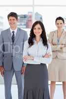 Young businesswoman crossing her arms in front of two relaxed co
