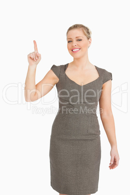 Pretty woman smiling while pointing something up