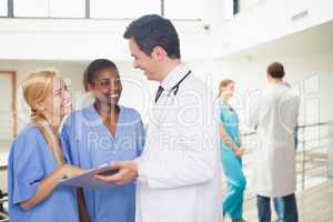 Doctor showing a clipboard to nurses