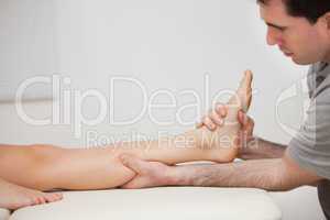 Serious physiotherapist holding the foot of a patient