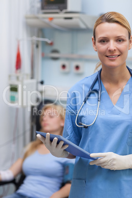 Nurse holding a clipboard next to a patient Nurse holding a clipboard next to a patient