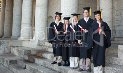 Five happy graduates posing