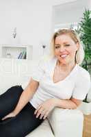 Casual woman smiling while sitting on a sofa