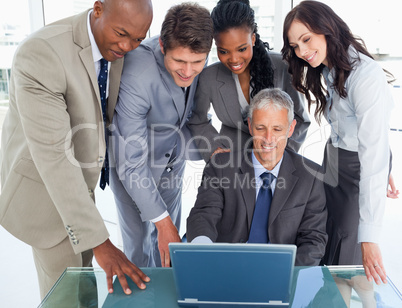 Four business people attentively listening to their mature manag