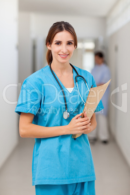 Smiling nurse holding a file while standing