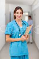 Smiling nurse holding a file while standing