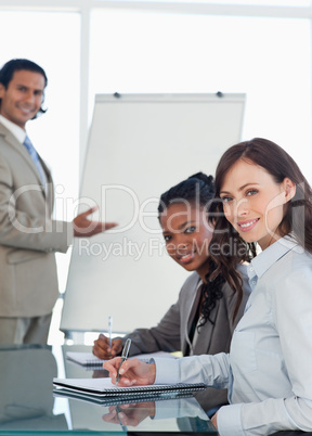 Two smiling executives working during a presentation while writi