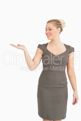 Woman smiling presenting something with her hand