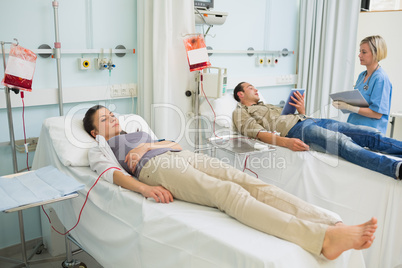 Two transfused patients lying on a medical bed