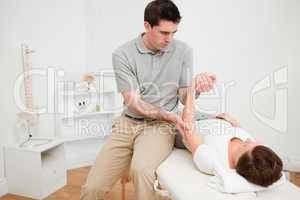Physiotherapist holding the arm of a brunette woman