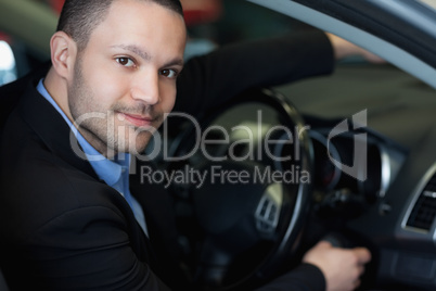 Man sitting on a car while turning on the engine