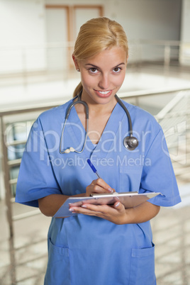 Nurse writing on a clipboard