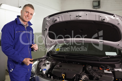 Smiling mechanic looking at a table computer