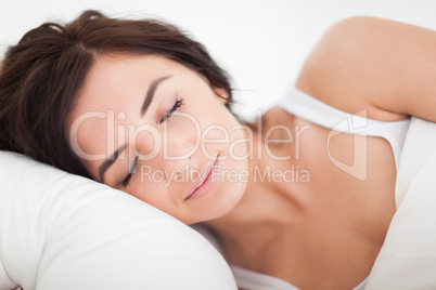 Peaceful brown-haired woman sleeping in the bed