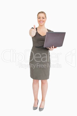 Woman holding a laptop while she is thump up