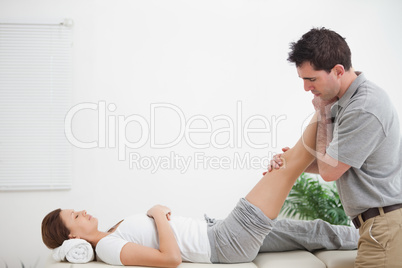 Chiropractor massaging a leg while placing it on his shoulder
