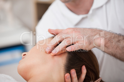 Doctor manipulating the side of the head of his patient