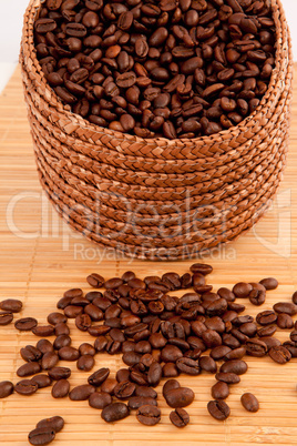 Close up of a basket filled with coffee seeds on a wooden tablec