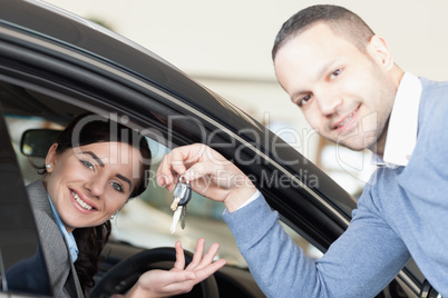 Man giving car keys to a woman