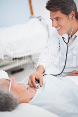 Doctor smiling while auscultating a patient
