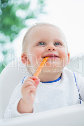 Baby biting a plastic spoon