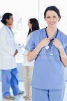 Young smiling medical intern wearing her uniform and standing in