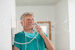 Surgeon smiling while holding a phone