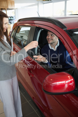 Businesswoman giving car keys to a customer
