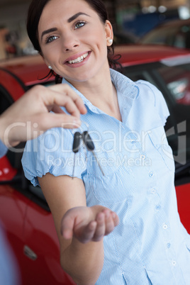 Woman smiles while receiving a car key