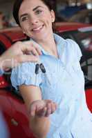 Woman smiles while receiving a car key
