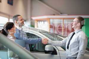 Salesman smiling while shaking the hand of a customer