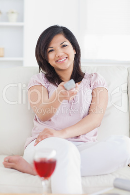 Woman smiling while holding a remote