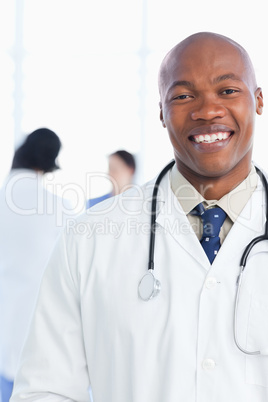 Medical intern showing a beaming smile in front of his team