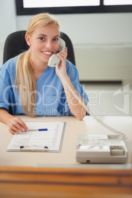 Blonde nurse holding a phone