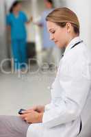 Doctor sitting on the floor while holding a tablet