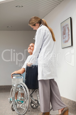 Patient sitting on a wheelchair looking at a doctor