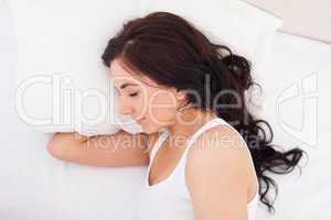 Brunette woman lying on the side while sleeping