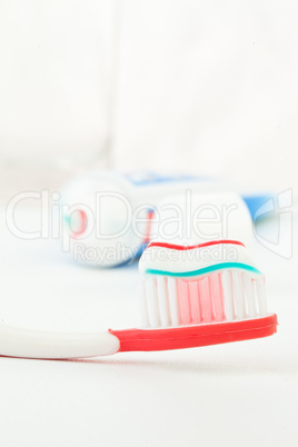 Tube of toothpaste next to a toothbrush