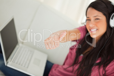Thumb-up of a student with a laptop