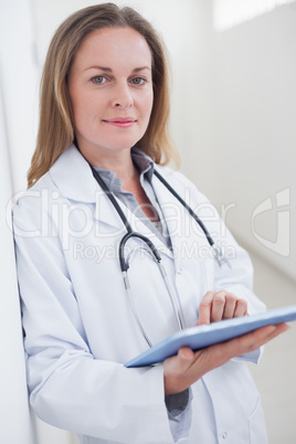 Doctor looking at camera while holding a tablet computer