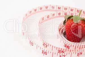 Close up of a strawberry surrounded by a ruler