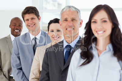 Three smiling business people in the background following their