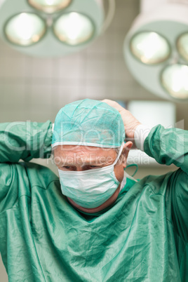 Surgeon putting on a face mask on his head