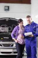 Mechanic showing a paper in a clipboard to a client