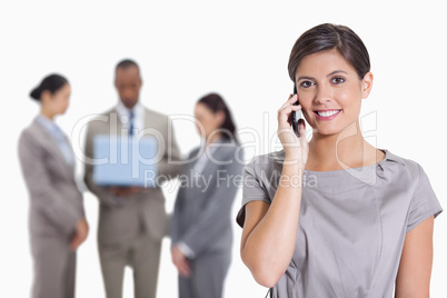 Woman with her head tilted slightly smiling on the phone and co-