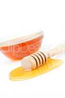 Honey dipper on the floor spilling honey in front of a honey bow