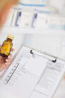 Pharmacist holding a bottle of drugs and a clipboard